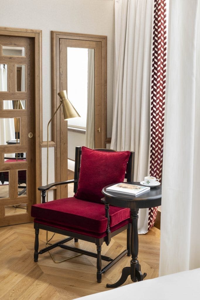 Butaca y mesa auxiliar en una habitación de Palacio Solecio